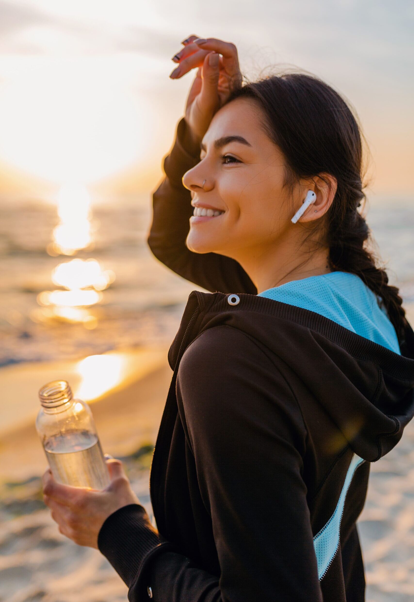 attractive-slim-woman-doing-sport-exercises-morning-sunrise-beach-sports-wear-thirsty-drinking-water-bottle-healthy-lifestyle-listening-music-wireless-earphones-hot-summer-day