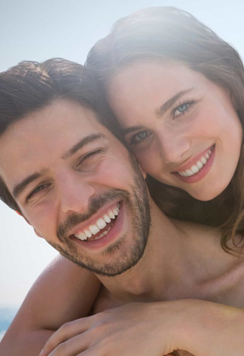 Happy couple hugging against view of the beach