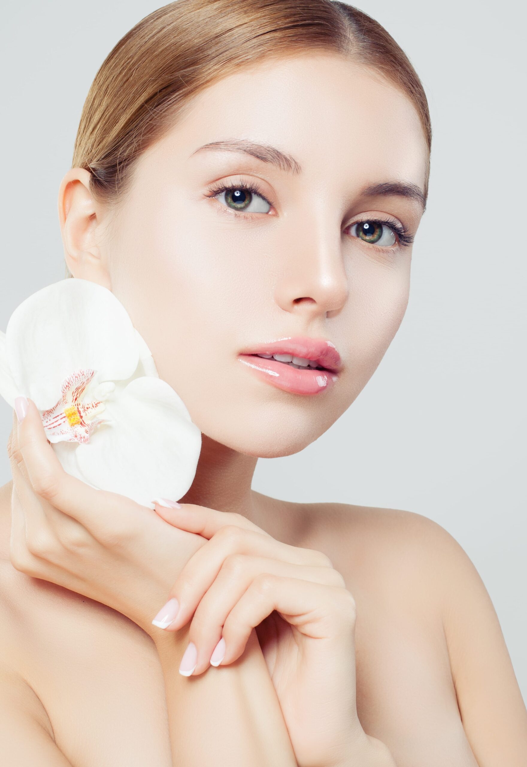 Beautiful spa woman with healthy skin and flower on white background, spa beauty, cosmetology, facial treatment and wellness concept