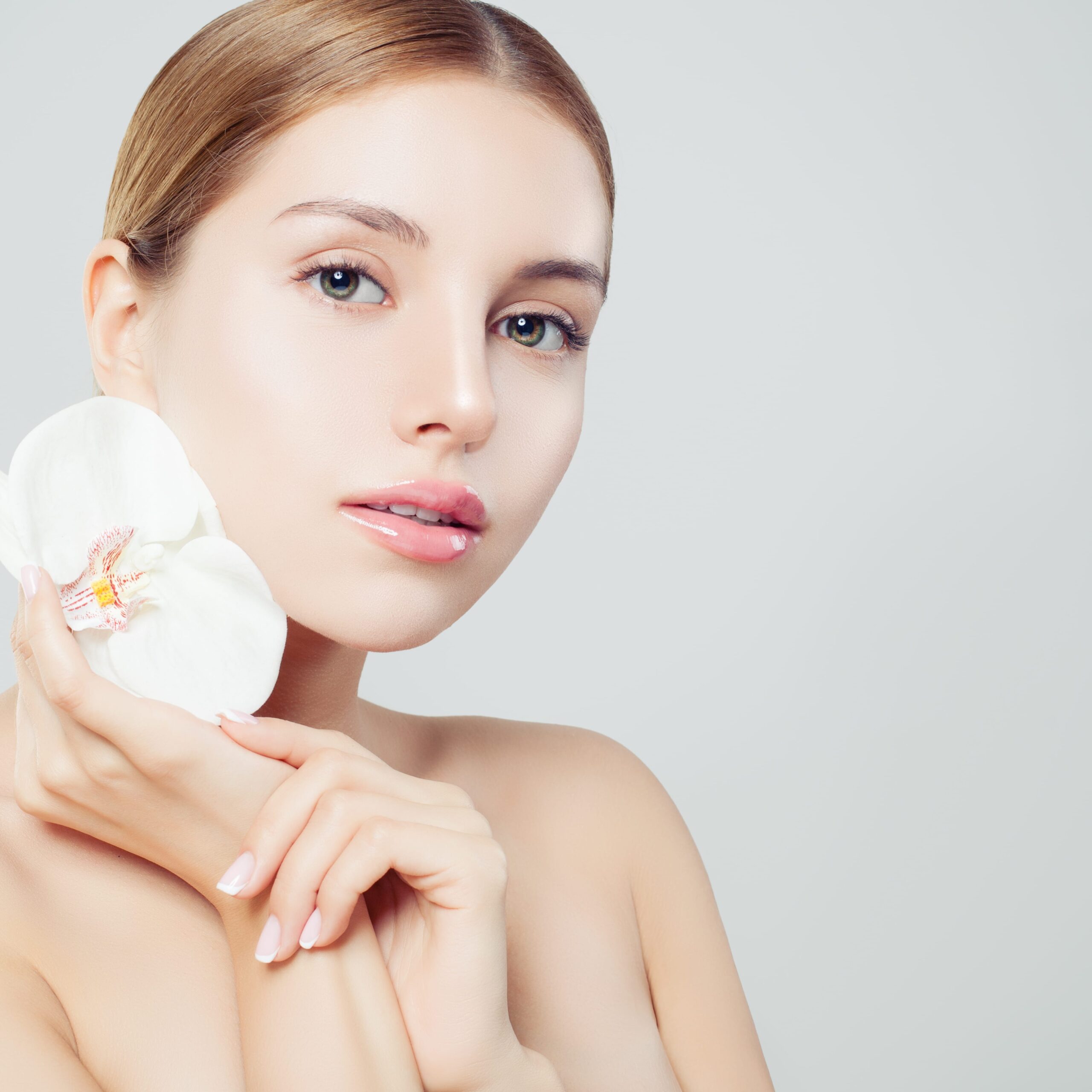 Beautiful spa woman with healthy skin and flower on white background, spa beauty, cosmetology, facial treatment and wellness concept