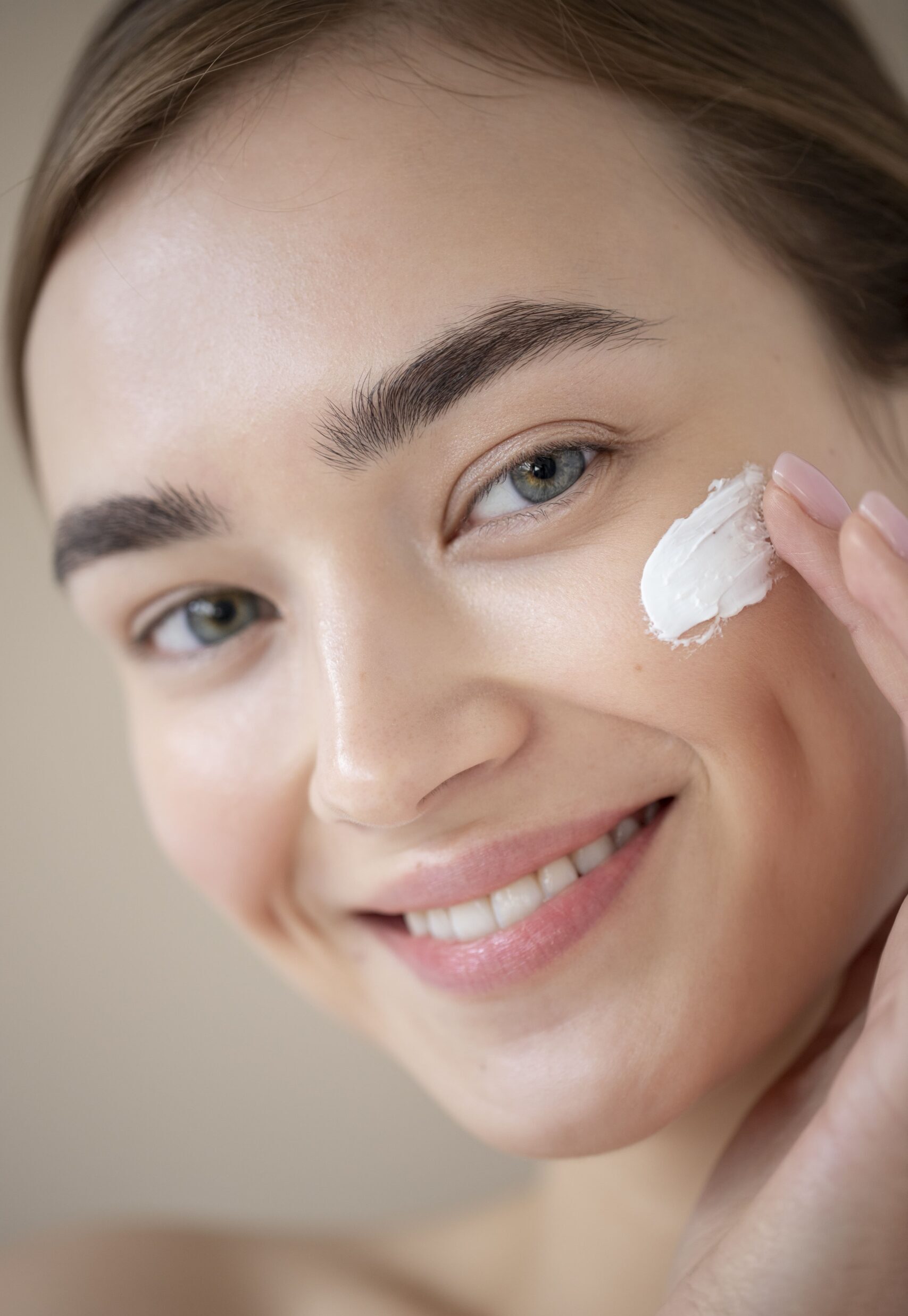 portrait-beautiful-woman-with-clear-skin-using-moisturizer-her-face